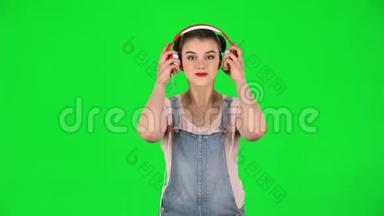 年轻漂亮的女孩听不同的耳机歌曲